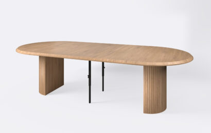 Okrągły stół na jednej nodze z lamelami dębowymi, rozłożony i poszerzony o trzy dodatkowe wkłady.