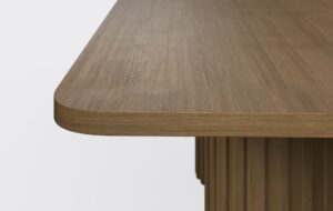 Obły blat prostokątnego stołu do jadalni.