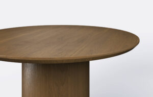 Okrągły stół rozkładany na jednej nodze, blat ścięty od dołu.