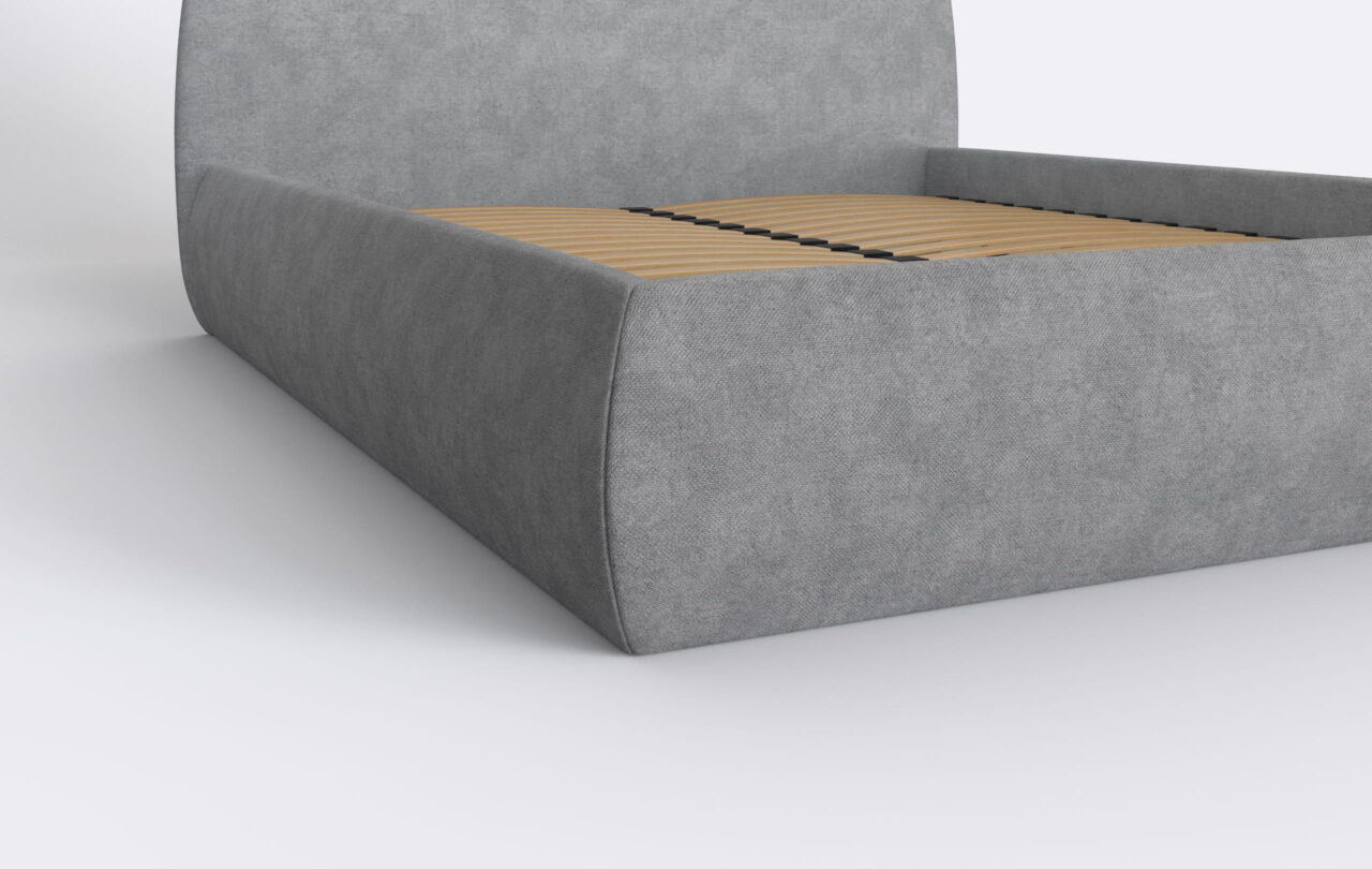 Łóżko z bokiem tapicerowanym w kolorze szarym.