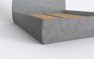 Łóżko z bokiem tapicerowanym w kolorze szarym.