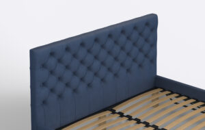 Granatowe łóżko tapicerowane z wysokim pikowanym zagłówkiem.