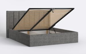 Tapicerowane łóżko z wysokim zagłówkiem, szare, z podnoszonym pojemnikiem.