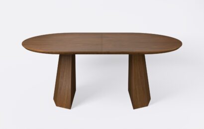 Owalny stół z funkcja rozkładania, na dwóch nogach, fornirowany, o wybarwieniu ciemnego dębu.