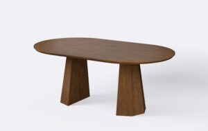 Stół owalny z możliwością poszerzania o dodatkowe wkładki, wykonany z naturalnego forniru, o ciemniej kolorystyce, minimalistyczny.