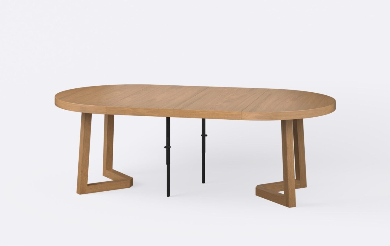 Rozłożony okrągły stół powiększony o dwie wkładki, noga kwadratowa o grubości sześciu centymetrów, o jasnym kolorze.