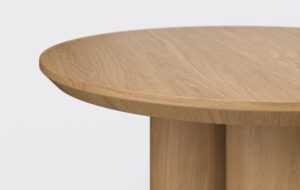 Stolik z blatem podciętym od dołu, fornirowany, w kolorze naturalnego dębu.