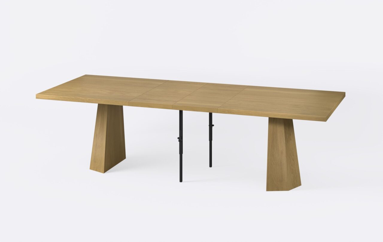 Rozłożony stół z prostokątnym blatem, poszerzony o dwie wkładki, o naturalnym wybarwieniu.