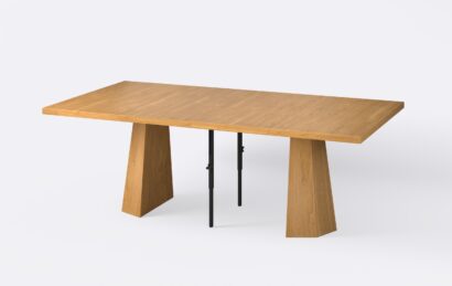 Kwadratowy rozłożony stół z dwoma wkładkami, fornirowany, o ciepłym jasnym wybarwieniu, na jednej nodze.