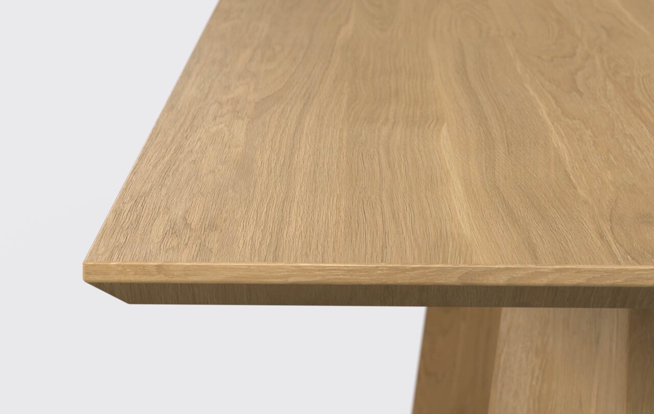 Blat prostokątnego stołu z podcięta od dołu krawędzią, wykonany z naturalnego forniru.