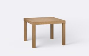 Klasyczny kwadratowy stół na czterech nogach, nogi wykonane z litego drewna, o jasnym naturalnym wybarwieniu.