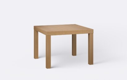 Klasyczny kwadratowy stół na czterech nogach, nogi wykonane z litego drewna, o jasnym naturalnym wybarwieniu.