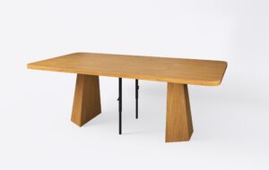 Jasny rozłożony stół na podstawie z dwoma wkładkami, wykonany z naturalnego forniru dębowego.