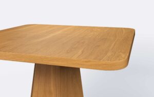 Kwadratowy stół z zaokrąglonymi rogami, krawędź blatu prosta, jasne naturalne wybarwienie.